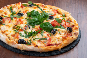 Pizza with salami and basturma, onions and basil