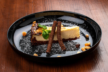 Cheesecake with nuts and chocolate tubes. On a decorative plate