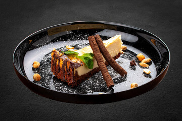 Cheesecake with nuts and chocolate tubes. On a decorative plate
