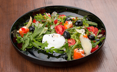 Salad with salmon and cheese rolls, arugula and poached egg.