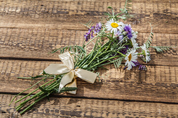 Bouquet of wildflowers on old wooden board.