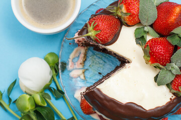 Homemade chocolate cake decorated with fresh strawberries, cup of coffee