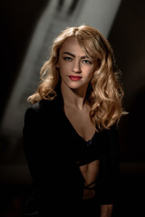 Fototapeta premium Beautiful fashionable sexy woman with wavy hairstyle posing on vintage background