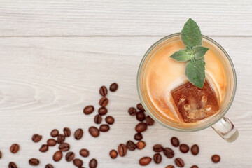 Glass of delicious milkshake or smoothie with chocolate ice and leaves of mint.