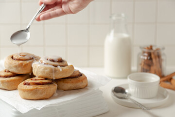 pouring glaze in cinnamon rolls