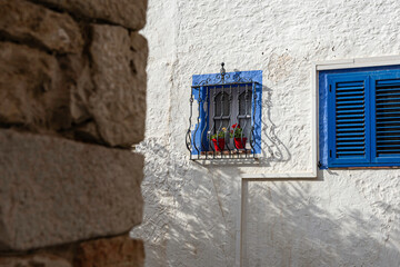 blue window on the white wall facade in a village