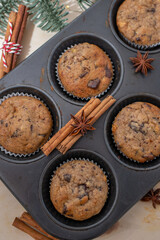 Fresh homemade gingerbread muffins in baking form on wooden table with Christmas decoration