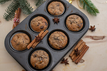 Fototapeta na wymiar Fresh homemade gingerbread muffins in baking form on wooden table with Christmas decoration