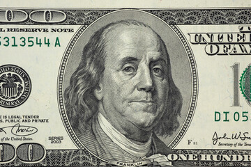 United States hundred dollars money bill closeup. Portrait of US president Benjamin Franklin on 100...