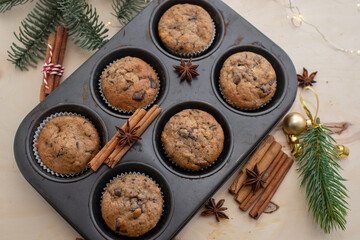 Fototapeta na wymiar Fresh homemade gingerbread muffins in baking form on wooden table with Christmas decoration