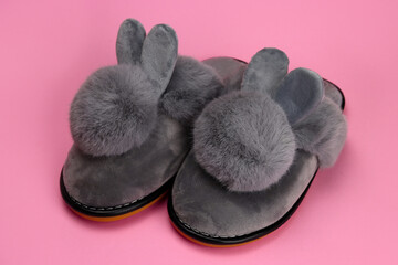 Slippers with fluffy ears, comfortable women's home shoes on a pink background