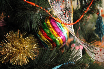 Colored Christmas tree decorations close-up. New year Christmas ball hanging on a branch of a tree.