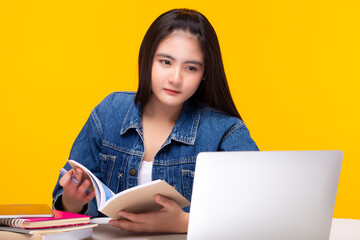 Young student watching lesson online and open book, she study at home. Student girl listen lecture watch webinar, look at laptop while teacher teaching on video call. distant education concept