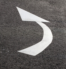 White arrow on asphalt road, traffic sign