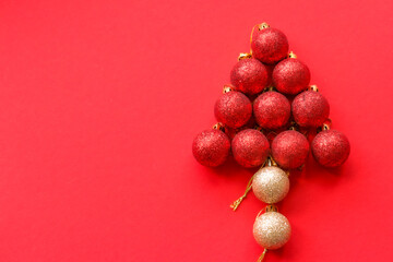 Christmas red background with a figure of a Christmas tree laid out of balls for decoration