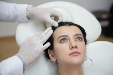 Naklejka premium Doctor trichologist examining womans hair scalp for eczema, dermatitis, psoriasis, hair loss, dandruff or dry scalp problem