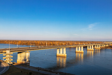 Fototapeta na wymiar Automobile bridge over the Ob river in Barnaul on a sunny autumn day. Altai Krai, Russia