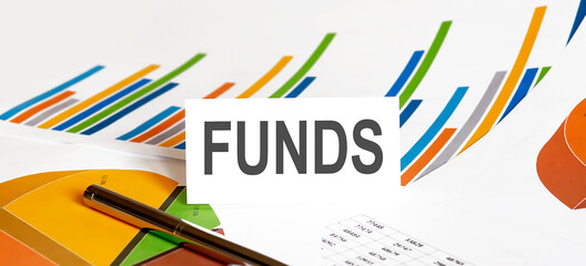 FUNDS text on paper on chart background with pen