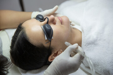 Young woman getting oxygen jet facial. Peeling procedure treatment at beauty salon or cosmetology...