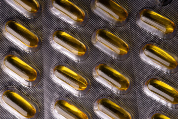 Close up view of a silver blister with yellow vitamine medical pills