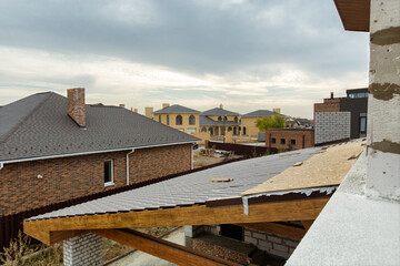 Roofs of new houses under construction in cottage village. View from the second floor of the house under construction.
