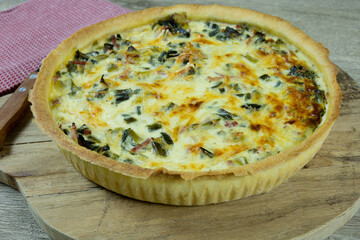 quiche aux poireaux et lardons sur une table	