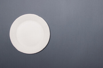white eco-friendly paper plate on gray colored paper background with copy space. top view. mock-up