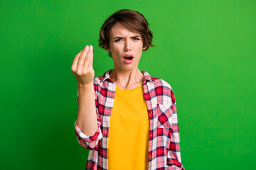 Portrait of attractive lady show arm gesture open mouth disbelief checkered shirt isolated on green...