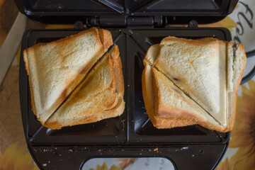 American hot cheese sandwich. Homemade sandwich with melted cheese on a sandwich maker. The view...