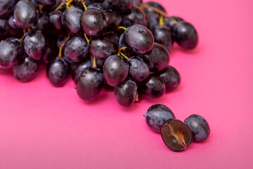 Top view bunch of ripe fresh black grape berry on pink surface