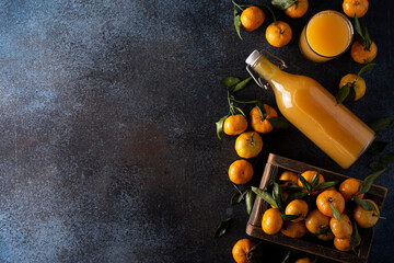 tangerine juice in a bottle and ripe tangerines in a wooden box