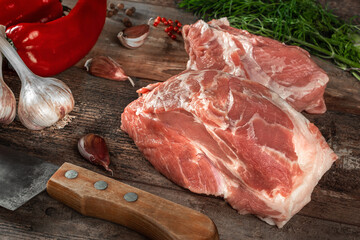 Piece of raw meat ready for preparation with greens and spices. Black background.