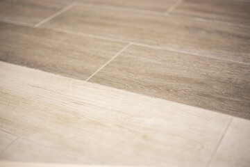 background of porcelain stoneware in two shades of light brown wood, blurred focus