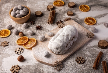 Christmas stollen on wooden board with fruits and nuts. Traditional german cake.