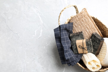 Natural tar soap in wicker basket on light grey table, top view. Space for text