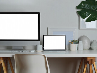 Workspace with mock up desktop computer and laptop on white table, clipping path