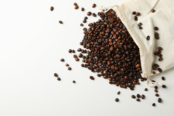 Bag with coffee seeds on white background