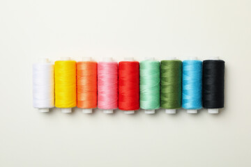 Color sewing threads on white background, space for text
