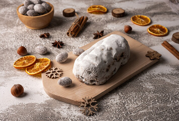 Christmas stollen on wooden board with fruits and nuts. Traditional german cake.
