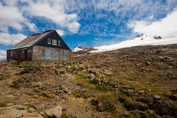 Cottages for tourists (refugio) on mountainside near volcano Tronador and glaciers. Andes, Argentina