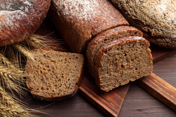 Tasty freshly baked bread on wooden table, closeup