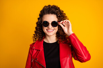 Close-up portrait of her she nice pretty cheerful fashionable wavy-haired girl touching round specs isolated on bright vivid yellow color background