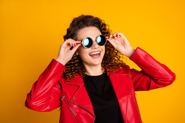 Close-up portrait of her she nice lovely cheerful wavy-haired girl touching round sun specs isolated on bright yellow color background