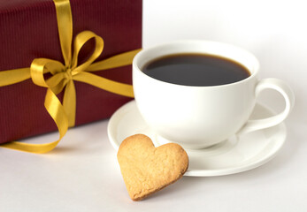 Сoffee cup on white background, heart shaped cookies and gift box