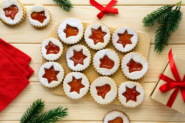 Christmas or new year linzer cookies in the shape of stars and bells with jam on a wooden background
