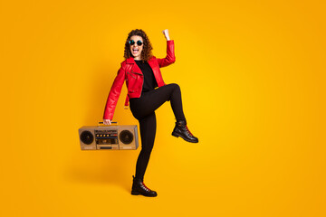 Fototapeta premium Full length body size view of cheerful excited glad wavy-haired girl carrying player dancing isolated bright yellow color background