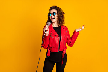 Portrait of pretty talented cheerful wavy-haired girl musician singing hit isolated on bright yellow color background