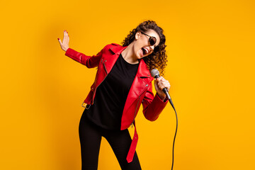 Portrait of attractive talented cheerful wavy-haired girl star enjoying singing romance song isolated on bright yellow color background