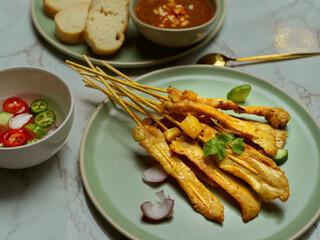 Grilled pork satay (Moo Satay) served with peanut sauce  and side dish