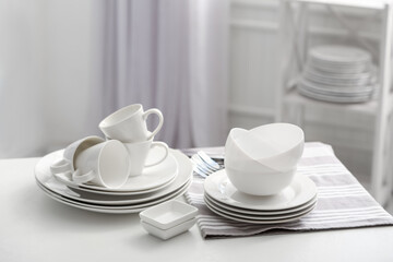 Set of clean dishware on white table indoors